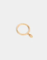 Anillo dorado con un dije colgante en forma de corazón.