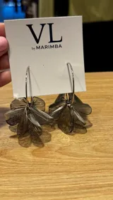 Aros colgantes plateados con forma de flor calada.