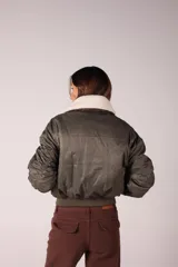 Campera bomber verde militar con cuello de corderito desmontable y cierre frontal.
