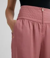 Pantalón color rosado de corte recto, con cintura ancha y pespuntes.