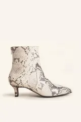 Bota corta de cuero vacuno con estampado animal print serpiente en tonos blanco y negro, con puntera fina y cierre trasero. Tiene taco chupete y suela de cuero.