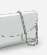 Cartera tipo billetera plateada de poliuretano con superficie metalizada y cierre sobre con botón. Incluye correa de cadena fina color níquel.