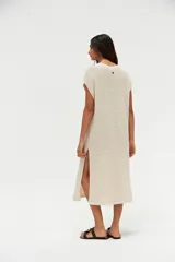 Vestido midi de punto calado color crudo, con escote en V, mangas cortas y aberturas laterales.