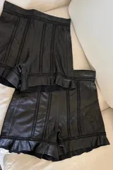 Short de cuero ovino negro con bordados y volados en el ruedo.