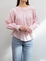 Blusa rosa claro de algodón con escote cuadrado, manga larga y bordado floral en el frente y las mangas.