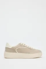 Zapatillas deportivas color beige, con suela alta de 3 cm y cierre con cordones.