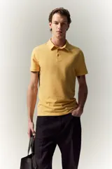 Remera polo de manga corta color amarillo, confeccionada en punto de algodón liviano. Tiene cuello clásico, tapeta con botones y corte ajustado.