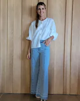 Pantalón de jean celeste de corte wide leg con costuras verticales al frente y ruedo con detalle de pespuntes blancos.