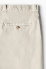 Bermuda color beige de sarga de algodón suave, corte estándar, con cierre y botón, bolsillos al bies y bolsillos insertados atrás con botón.