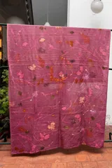 Mantel rectangular de lino color rosa con estampado de hojas y flores en tonos naranja, marrón y blanco.