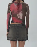 Minifalda de jean gris oscuro con efecto lavado, tiro bajo y ruedo desflecado.