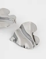 Aros colgantes cortos con forma de corazón de metal dorado con textura ondulada.