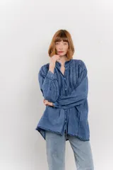 Camisa oversize blanca de algodón con pliegues frontales.
