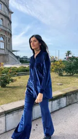 Camisa azul de terciopelo, corte oversize, con cuello camisero, manga larga y cierre frontal con botones.