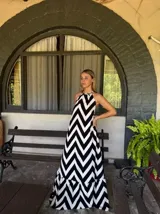 Vestido largo con estampado de zigzag blanco y negro, con cuello halter y falda amplia con volantes en el ruedo.