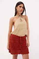 Top de lino color azul con escote halter cruzado y detalle de hebilla metálica cuadrada en el cuello. Presenta una pequeña abertura frontal tipo gota y un diseño de calce relajado.