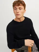 Sweater negro de punto con cuello redondo y mangas largas.