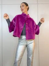 Chaqueta corta fucsia de terciopelo con cuello alto, mangas 3/4 amplias y cierre frontal con botones.