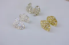 Par de aros colgantes de bronce y alpaca con diseño abstracto calado.