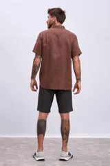 Camisa celeste de lino, de corte clásico, manga corta y cuello italiano.