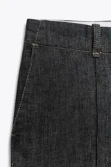 Pantalón de jean azul oscuro, de tiro alto y corte bootcut. Presenta bolsillos delanteros y traseros.