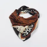 Pañuelo cuadrado de seda color marrón con estampado de letras y detalles en animal print.