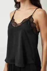 Blusa color crudo con lunares dorados, breteles finos y escote en V con detalle de encaje.