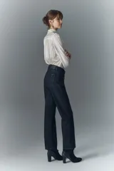 Pantalón de jean negro con corte recto y detalles brillantes.