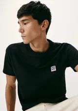 Camiseta blanca de algodón con cuello redondo y mangas cortas. Estampa rectangular con borde negro que contiene la frase "NATURAL ATMOSPHERE" en letras mayúsculas y una imagen de montañas y mar.