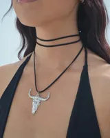 Gargantilla doble de cordón negro con dije plateado de cráneo de toro.