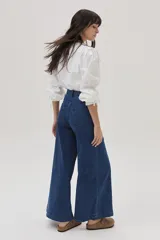 Blusa blanca de mangas largas abullonadas con puños elásticos y lazos.