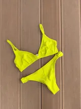 Bombacha de bikini color verde lima con detalle de nudo en los costados.