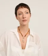 Collar mediano con cadena de abalorios color ámbar y colgantes de peces dorados. Cierre con mosquetón. Accesorio de bisutería.