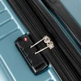 Valija grande rígida de policarbonato color celeste, con cuatro ruedas, candado TSA integrado y compartimento interno con cierre. Marca Munich.
