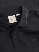 Chomba Calvin Klein negra de algodón con cuello clásico con detalle texturizado, cierre de dos botones y logo tonal en el pecho.
