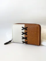 Billetera pequeña de cuero color camel y crudo, con cierre metálico y detalle de cruces bordadas en hilo negro.