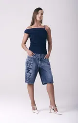 Short de jean azul con corte relaxed hasta la rodilla y bordado de caracteres orientales en negro.