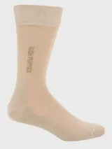 Calcetín formal de largo medio, color beige, con banda elástica superior y logo de Hush Puppies bordado en el lateral de la caña. Presenta refuerzo en el talón y puntera.