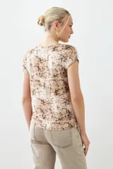 Blusa beige con estampado animal print, escote en V y mangas cortas.
