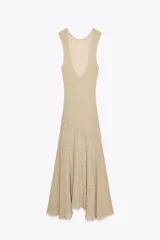 Vestido midi de encaje color beige, sin mangas, con espalda descubierta y bajo asimétrico con volados.