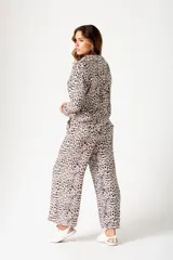 Pantalón palazzo beige con estampado animal print, cintura elástica y corte amplio.