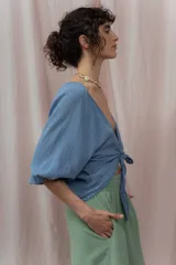 Blusa color mostaza de lino, con escote en V y mangas cortas abullonadas. Se ata en la parte delantera con dos cordones.