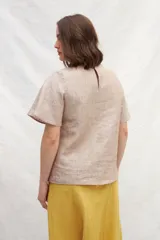 Blusa blanca de lino con escote en V y mangas cortas amplias.