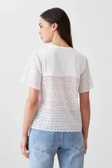 Remera blanca de algodón con mangas cortas con detalle de broderie calado.