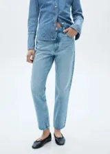 Pantalón de jean celeste claro, corte mom fit, con tiro alto, cinco bolsillos y cierre con cremallera y botón.