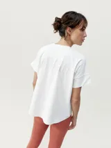 Remera de manga corta con calce oversize y cuello redondo. Confeccionada en tejido de poliéster, presenta un diseño de hombros caídos y un sutil estampado tonal en el pecho.