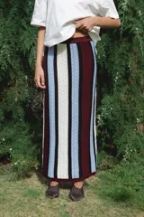 Falda larga tejida con rayas horizontales de colores rojo, amarillo, blanco y marrón.
