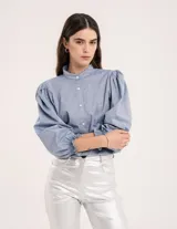 Blusa blanca con cuello mao, botones en la delantera y frunces en los hombros, con tajos laterales.