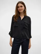 Camisa negra de corte clásico con cuello, manga larga y bolsillos en el pecho.