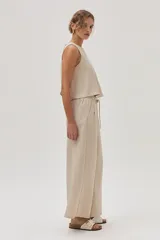 Pantalón de vestir color beige, de corte ancho y tiro alto, con cintura elástica ajustable con cordón.